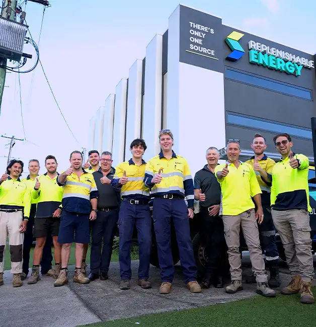 The Replenishable Energy team in hi-vis workwear giving thumbs up outside the company building